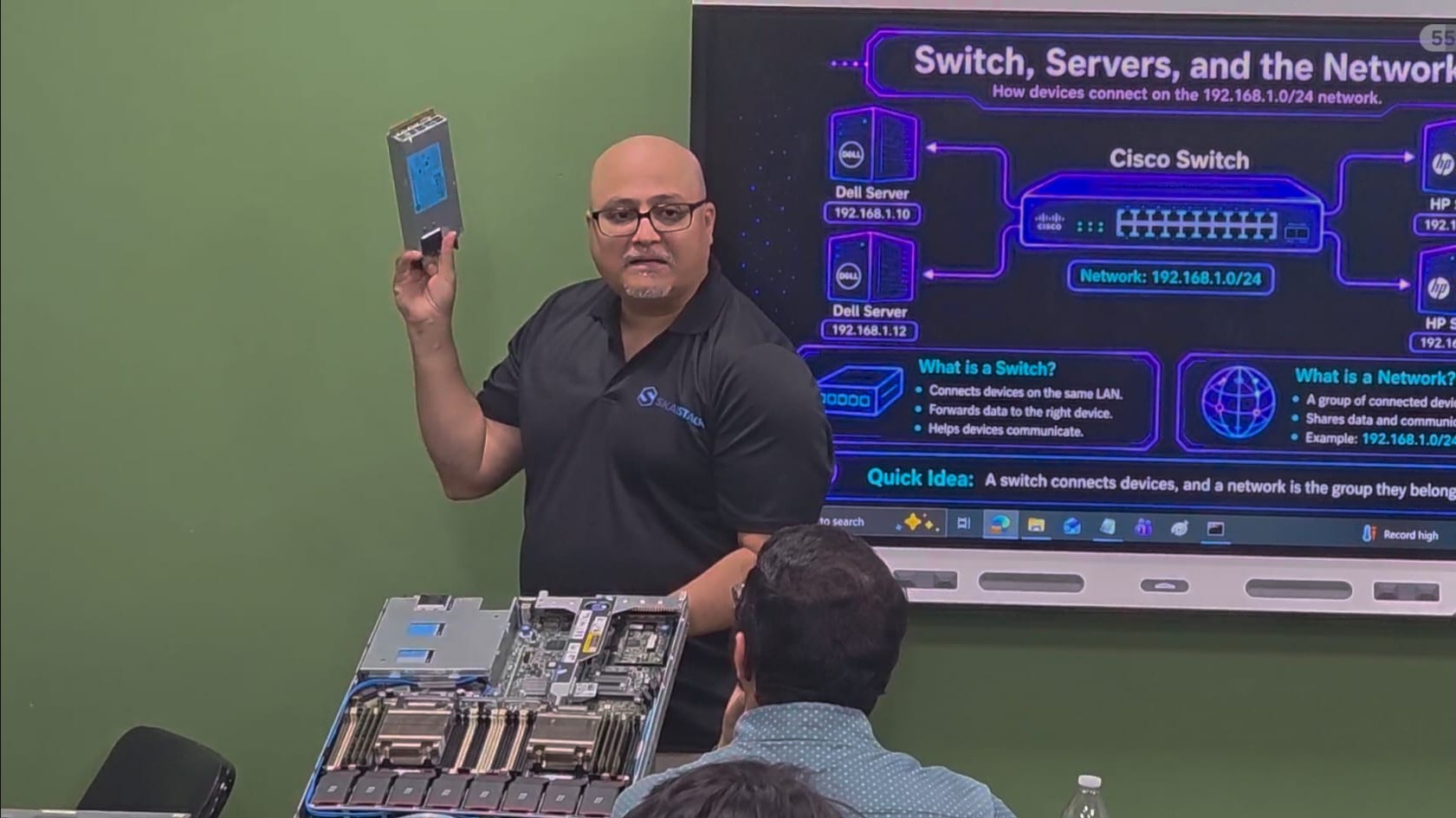 Instructor demonstrating server hardware during a networking lesson